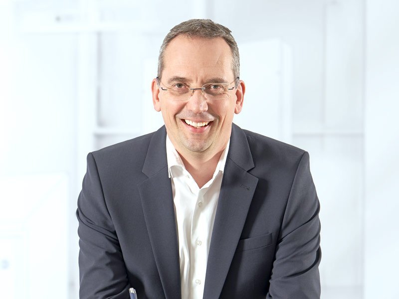 Herr Müller mit einem Stift in der Hand.