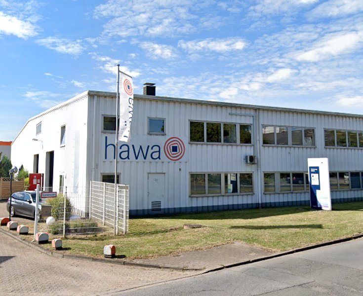 Das häwa Duisburg Verwaltungsgebäude. Am Eingang sind zwei häwa Fahnen.
